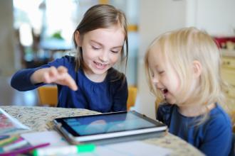 
		Zwei Kinder spielen mit einem Tablet
	